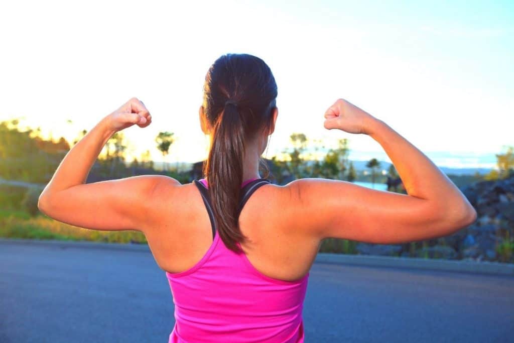 girl showing arm and upper back muscles during a walk