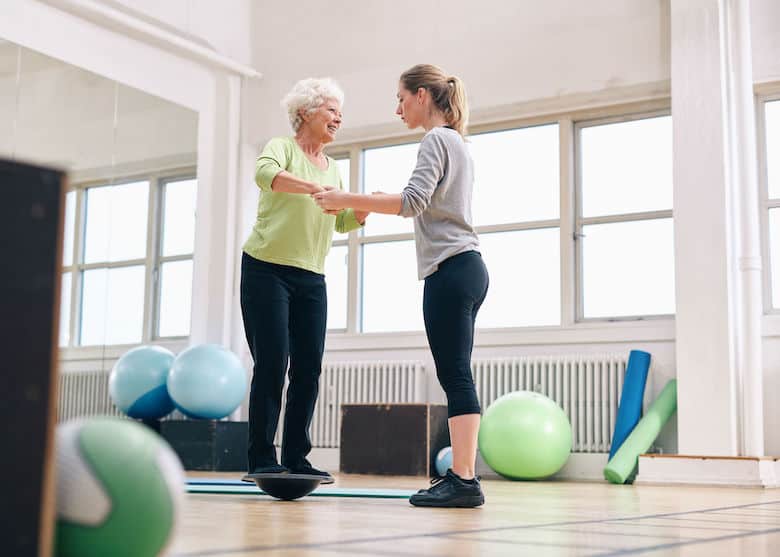 Senior with help on a balance board