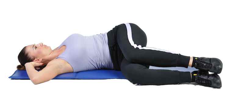 Woman doing a torso stretch on mat.