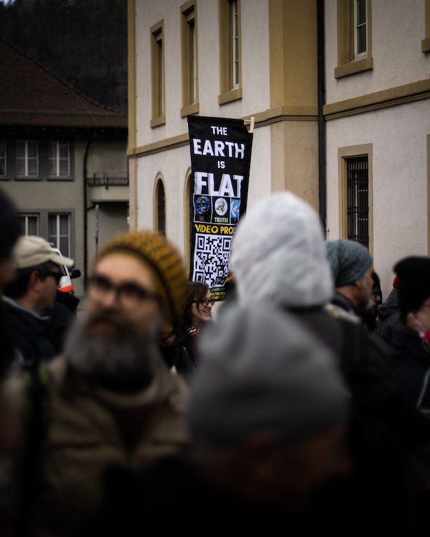 Protest march with banner “the earth is flat”