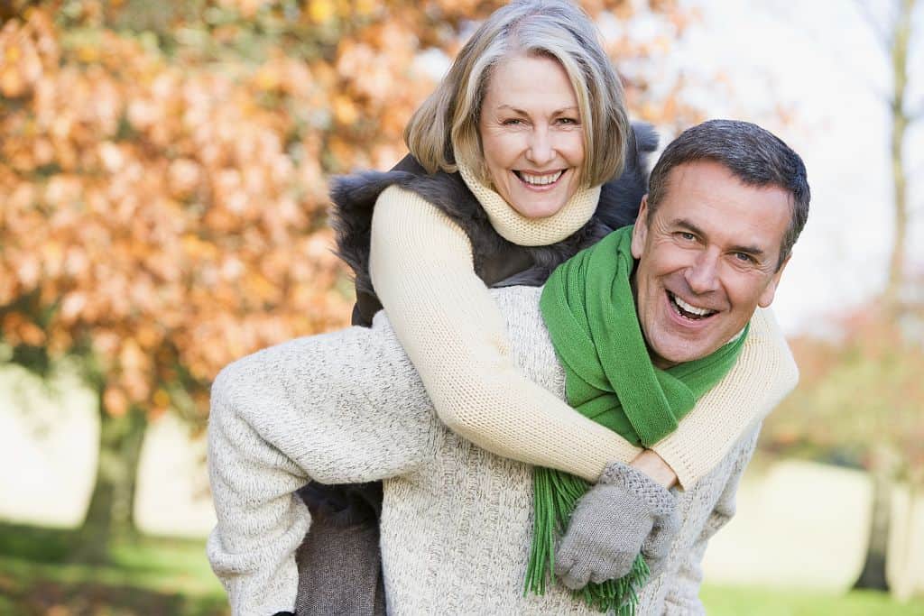 middle aged man giving woman piggyback ride - happy life hacks