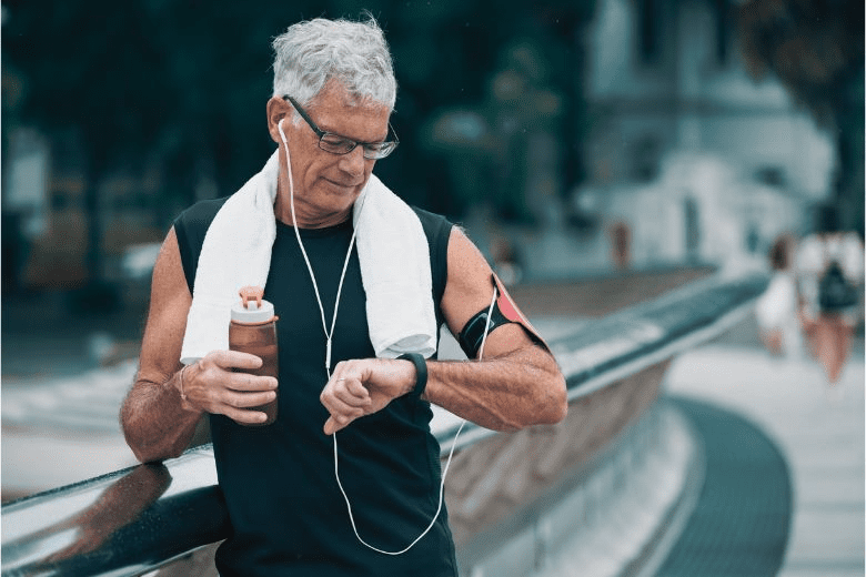 Older man paused on a run to check his fitness tracker