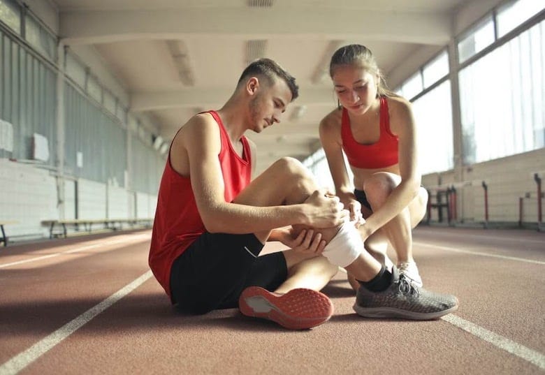 Girl tending to man suffering from lower leg pain