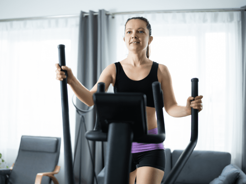 Young girl on a elliptical trainer at home