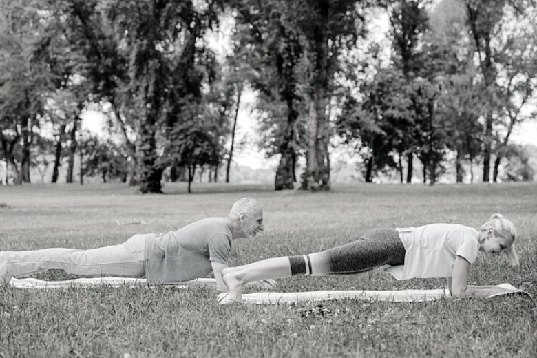 Middle age couple doing a “plank” outside to improve their ab muscles